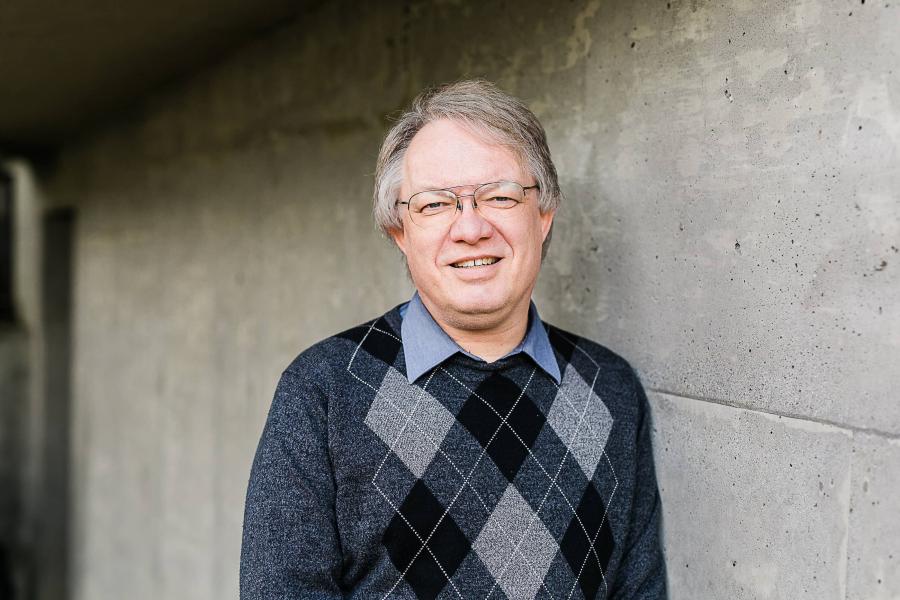 Glen Van Brummelen standing in front of grey wall