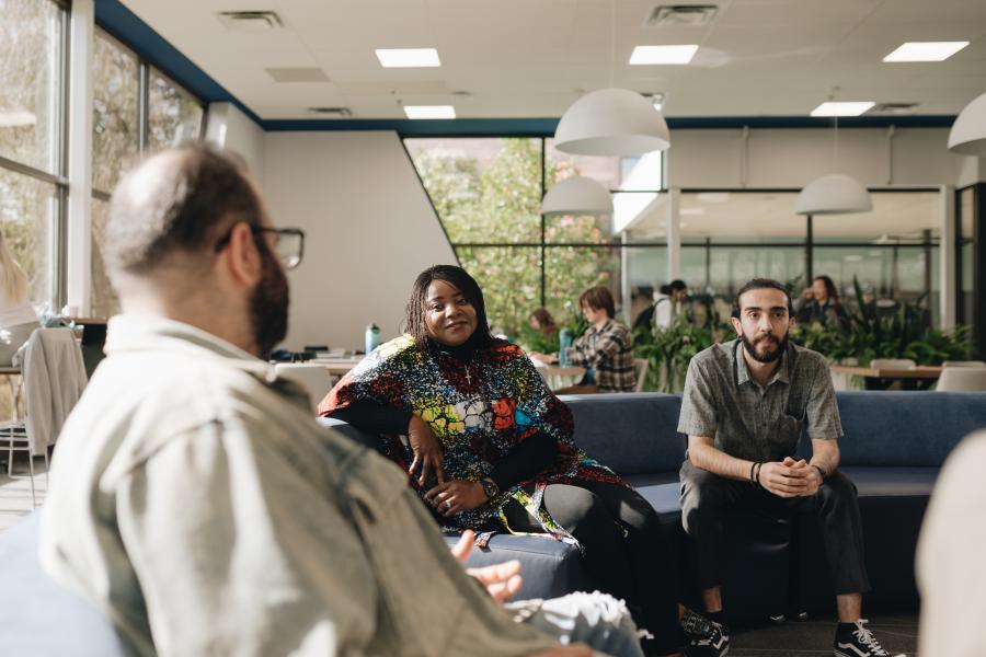 three people seated and having a discussion