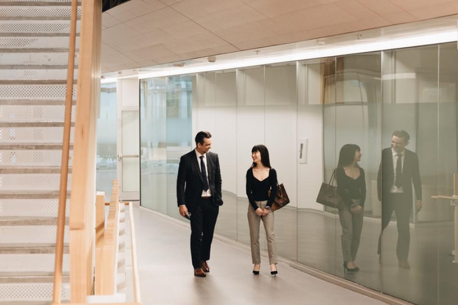 student walking with professor in business building