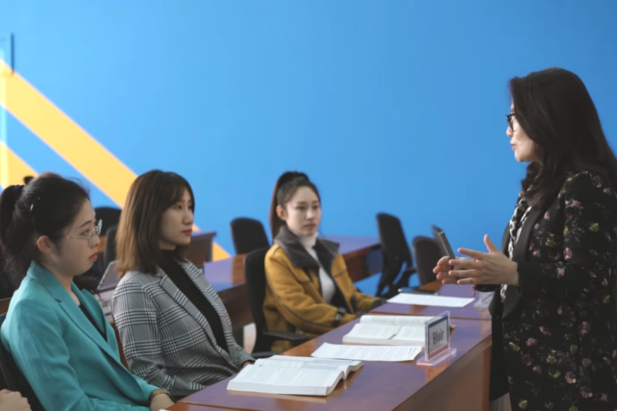 women sitting in classroom with teacher standing