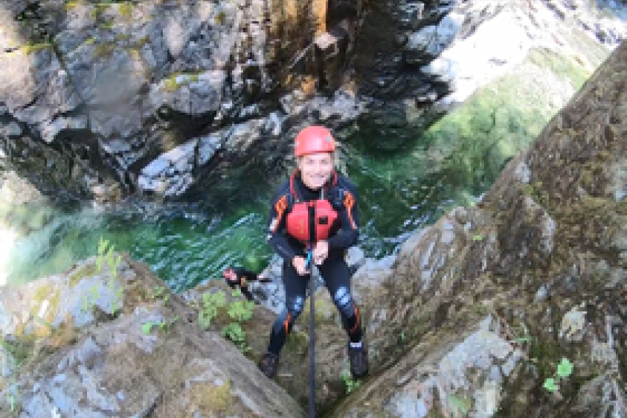 person climbing rocks above water