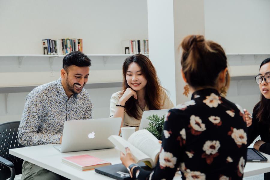 students smiling and working at a table