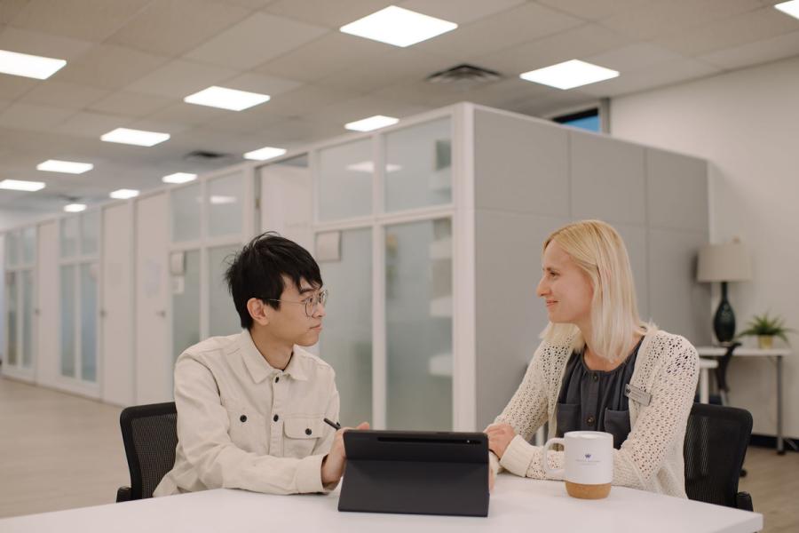 academic advisor advising student with device
