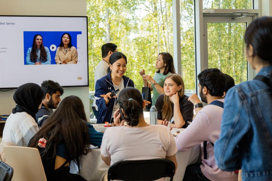 woman talking to a table of students in the Global Lounge