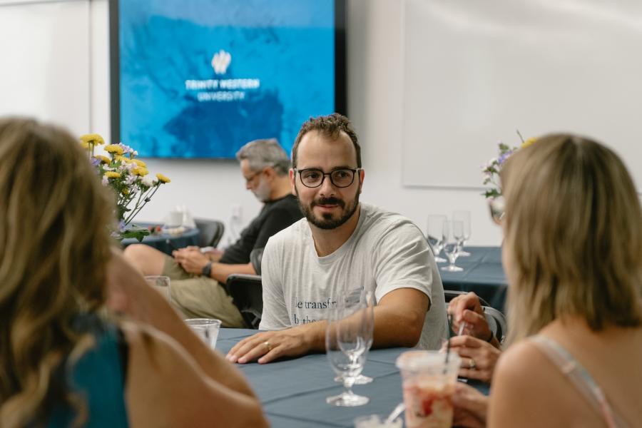 Andrew de Groot sitting at a table talking to people