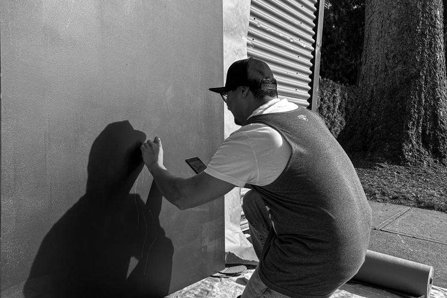 Mauricio Martinez doing artwork on a dark canvas