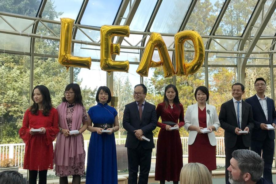 Awardees stand in front of an audience
