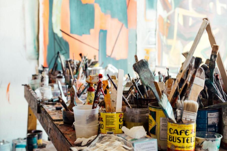 Table full of paint and paintbrushes.