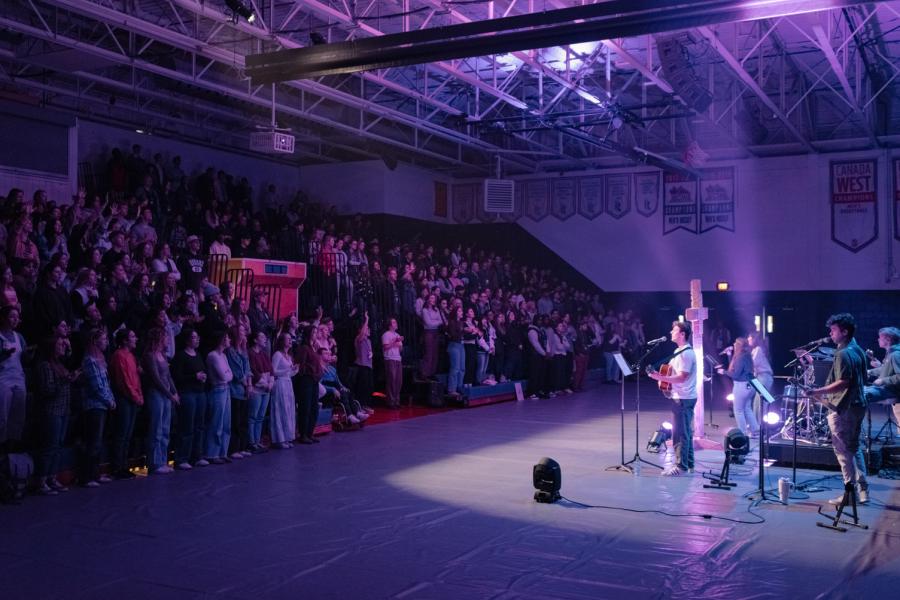 A worship band in front of a congregation of students