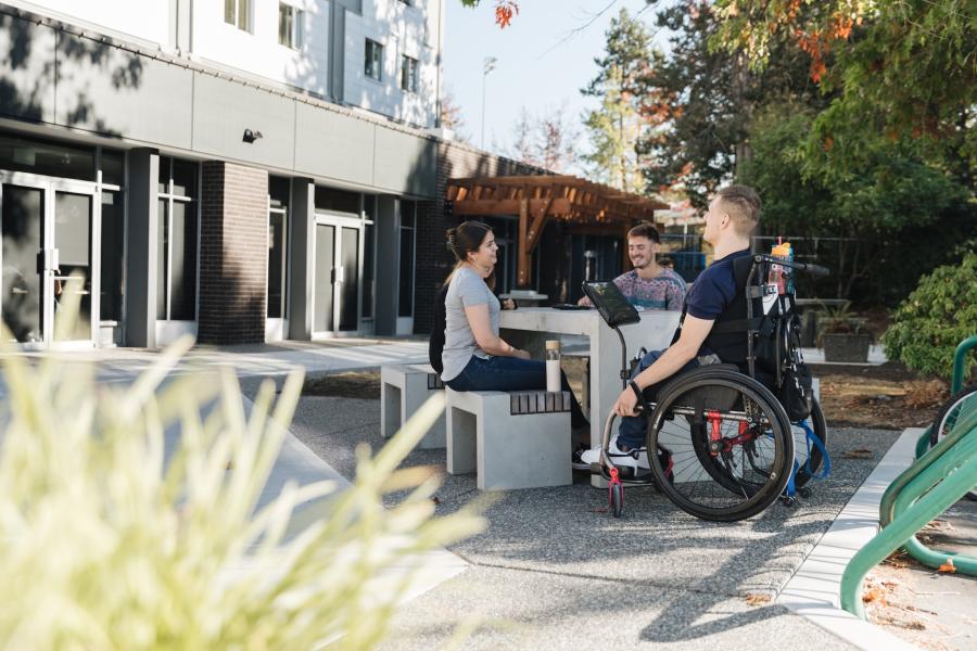 group of people at picnic table in front of DeVries Centre