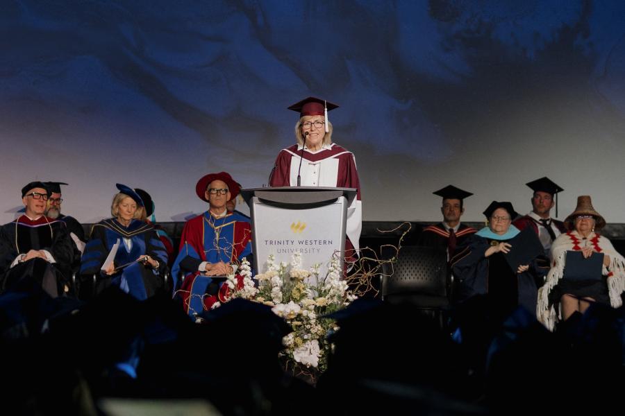 Dr. Susan Wendell in regalia speaking at graduation