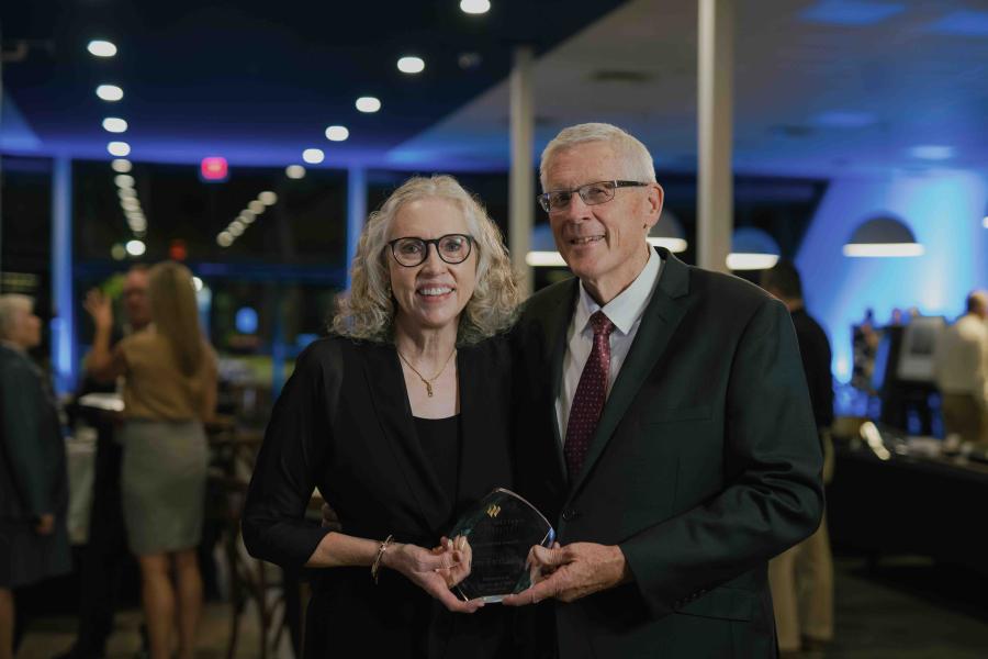 Darwin and Darlis Anderson holding the 2026 Live Faithfully Award at TWU’s Alumni Awards Dinner.