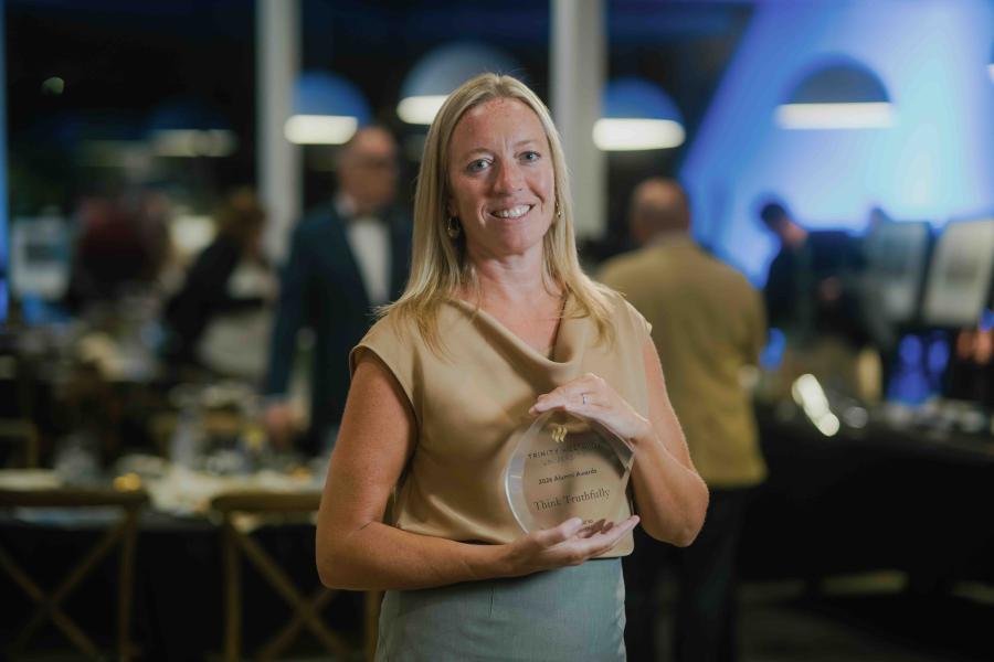 Sara Kraushar smiling and holding her 2026 Think Truthfully Award at TWU’s Alumni Awards Dinner.
