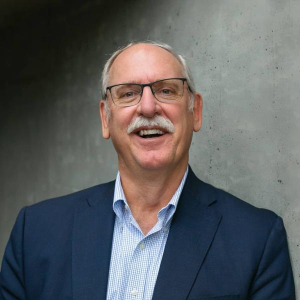 Kevin Sawatsky headshot in front of grey wall