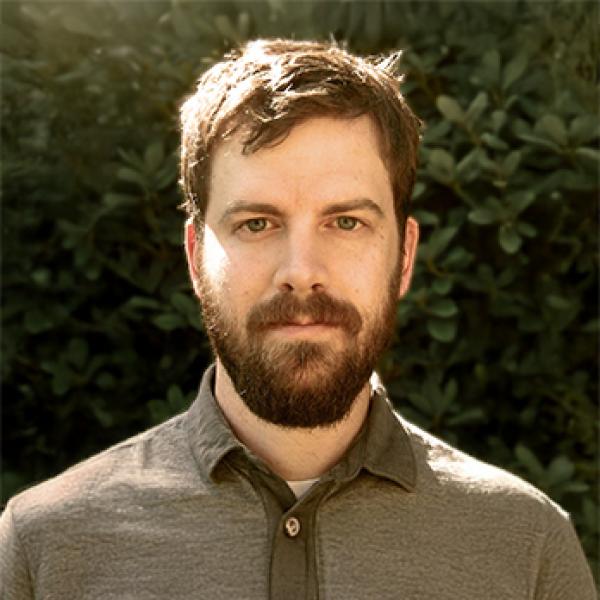 Andrew Klager standing in front of greenery