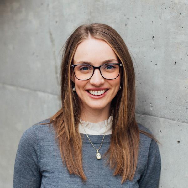 Leah Cameron standing in front of a grey wall
