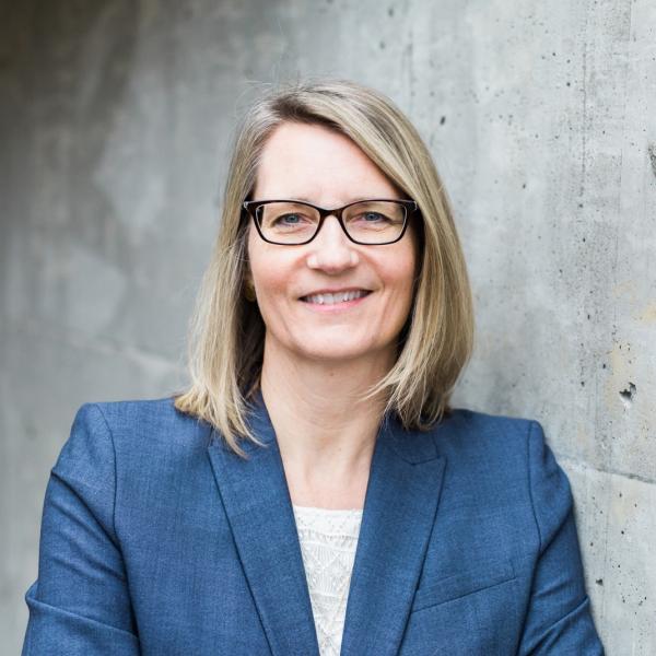 Sonya Grypma standing in front of grey wall