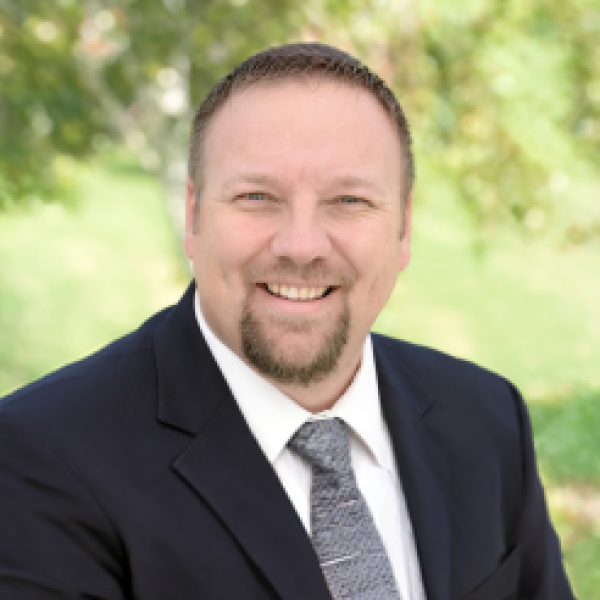Brian Albright in a suit in front of green background