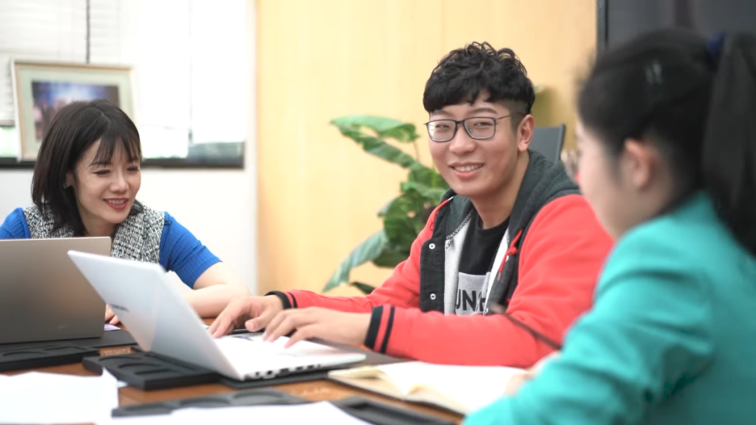 students looking at laptop smiling