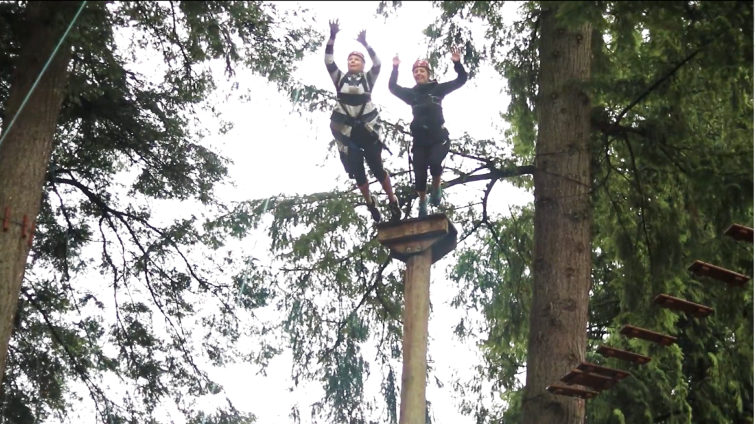 people jumping off high ropes course
