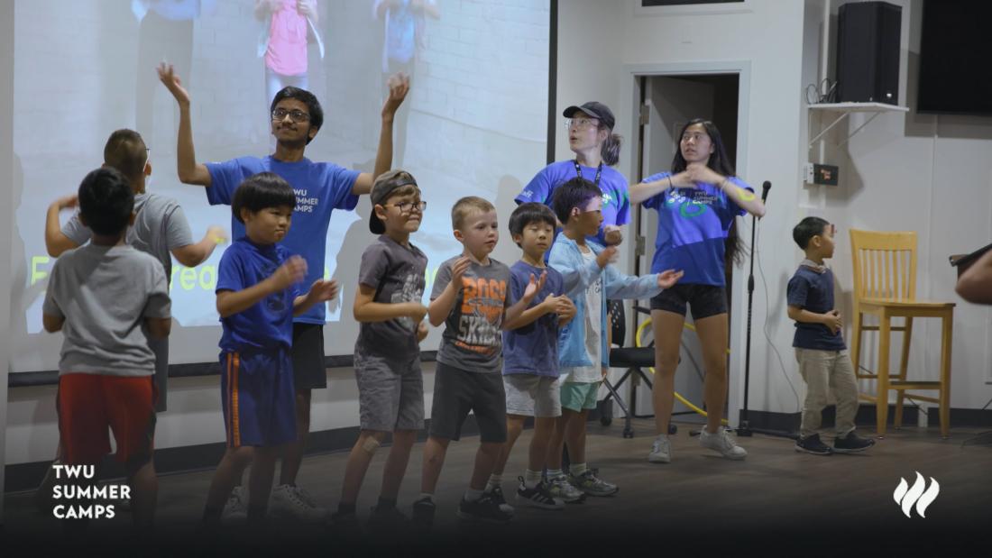kids dancing on a stage with camp leaders