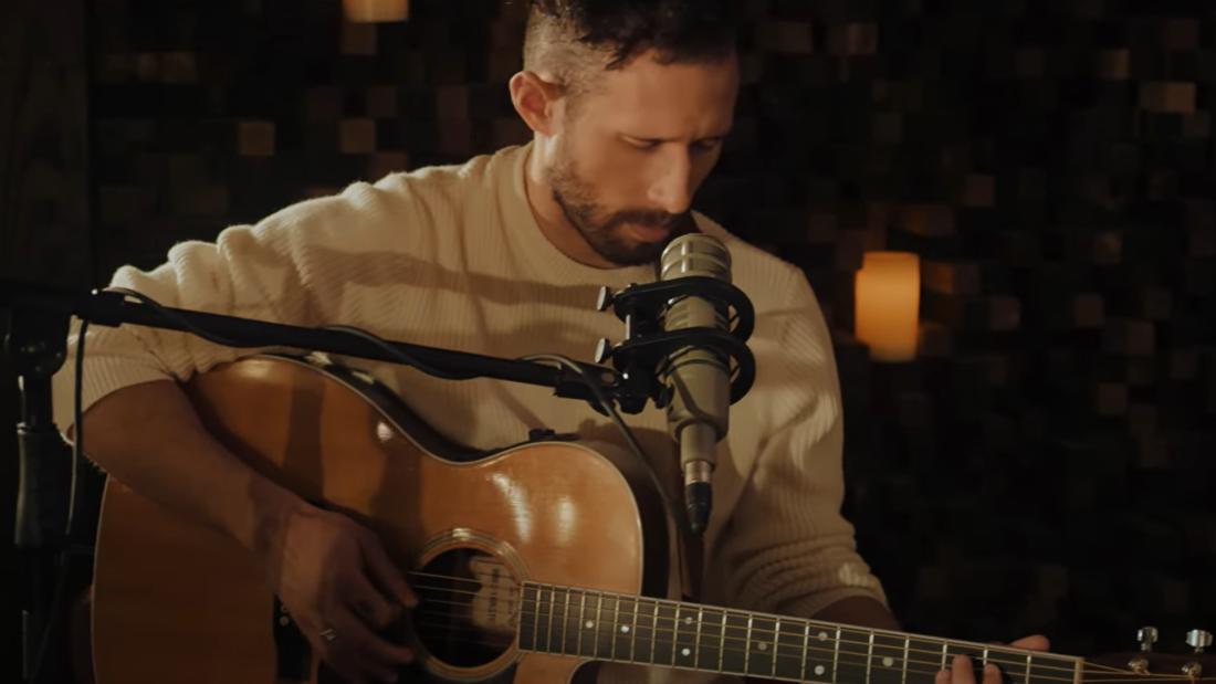 Man playing a guitar and singing.