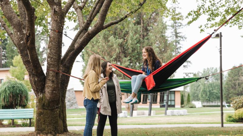 Students on Langnley campus in hammocks talking.