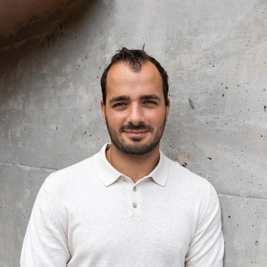 andrew de groot's headshot in front of grey wall