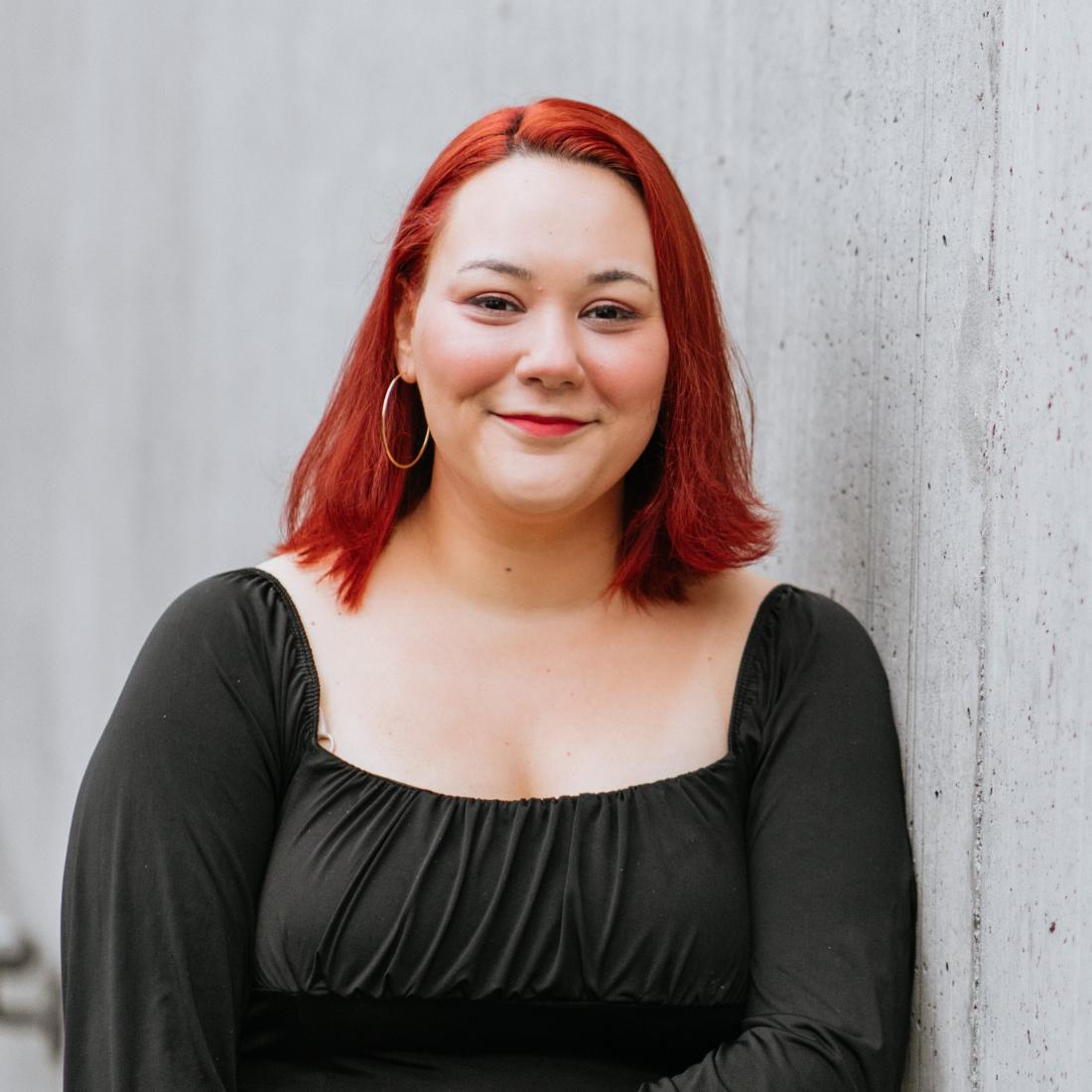 Audrey Tupaj against a grey wall.