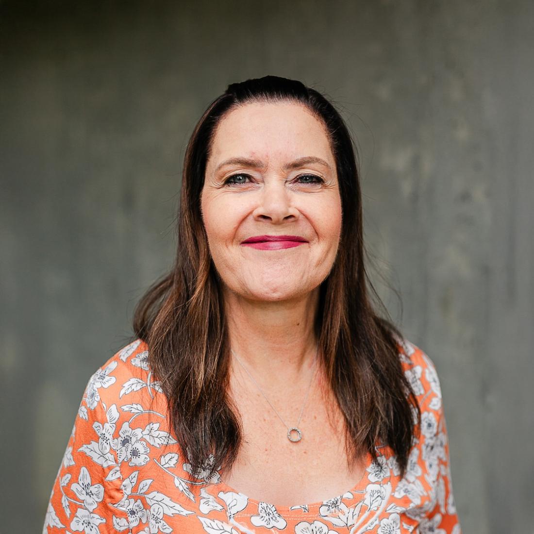 Deborah Carmichael standing in front of a grey wall