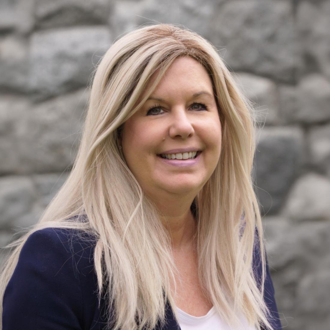 Headshot of Shannon Magnuson in front of a stone wall