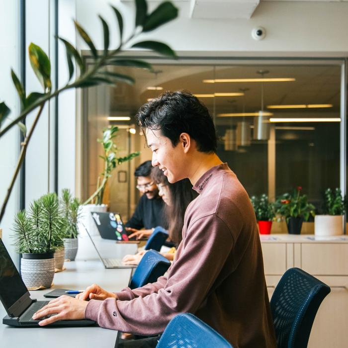 Male student sitting and working on laptop. Richmond Campus.