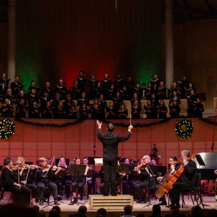 conductor leading orchestra and choir