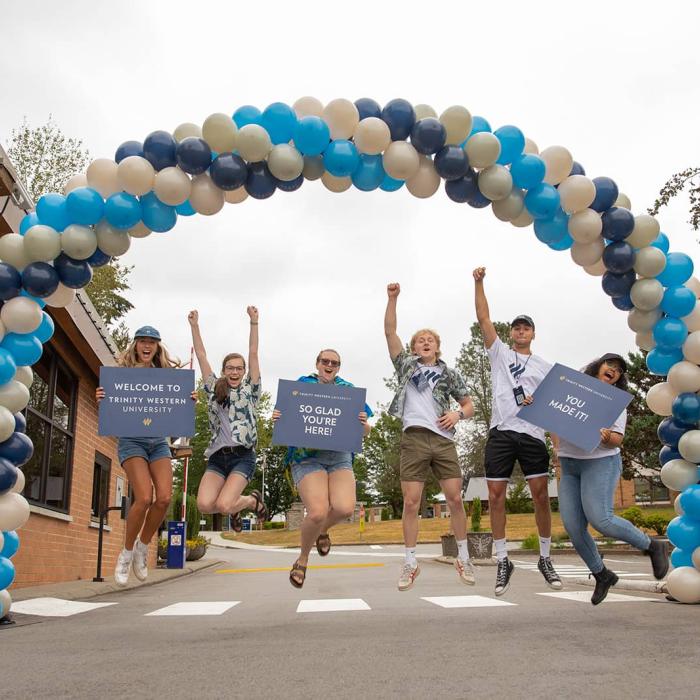 students welcoming under a balloon arch