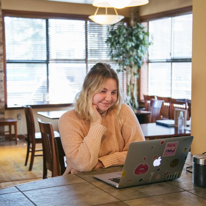 female student looking at laptop and smiling