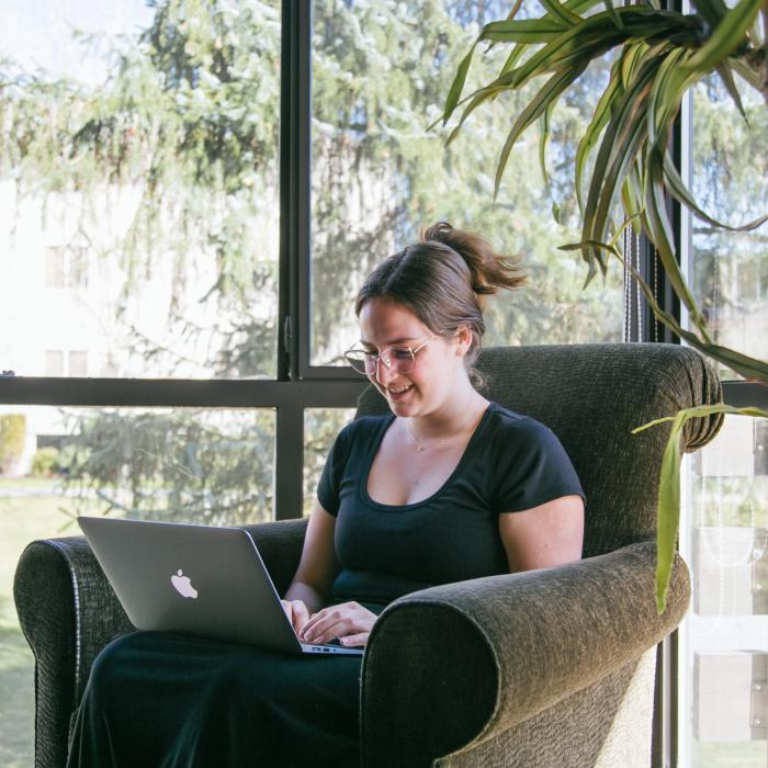 student using a laptop and smiling