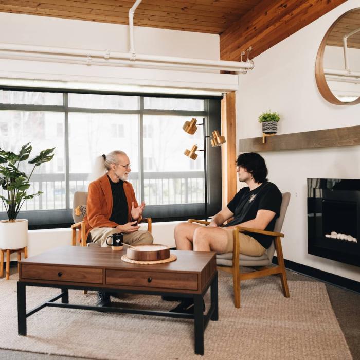 two people sitting in room talking