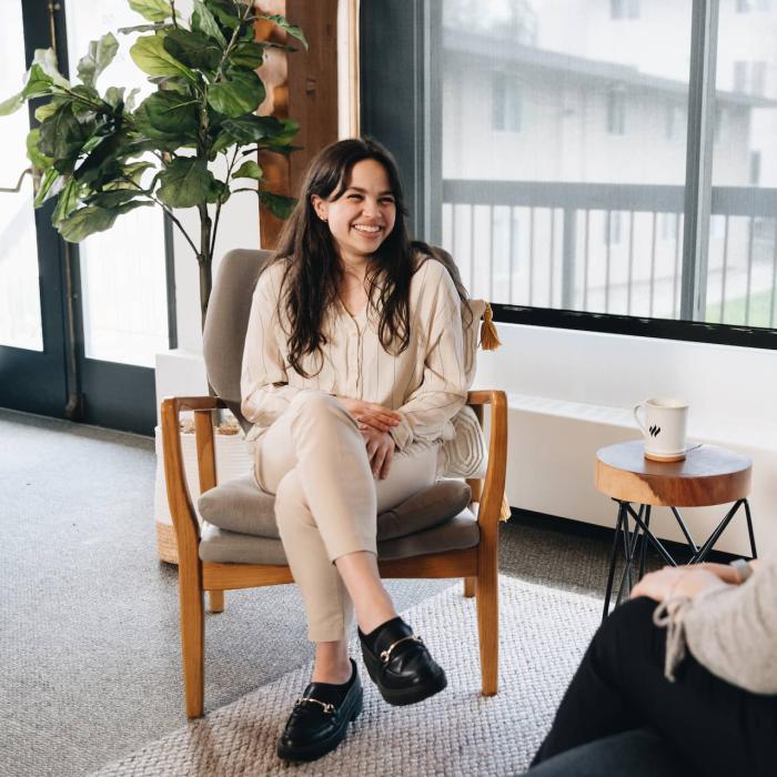 woman sitting in chair smiling at another woman