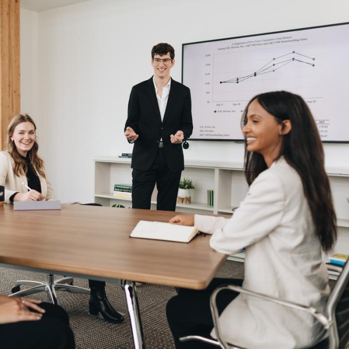 team of business students discussing graph chart on screen