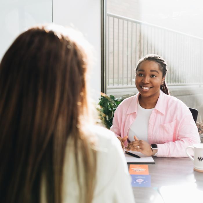 student sitting at table across from another person