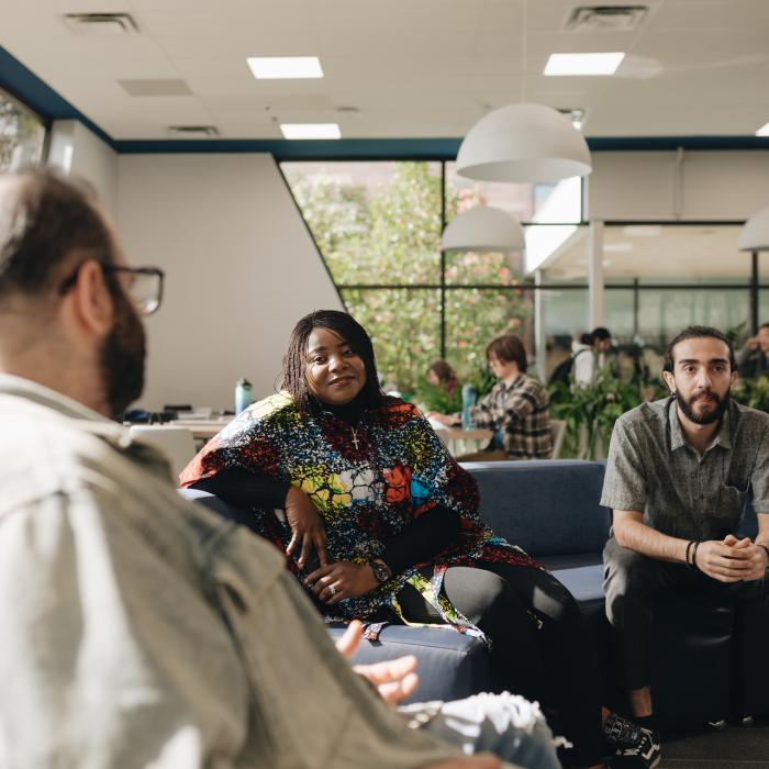 three people seated and having a discussion