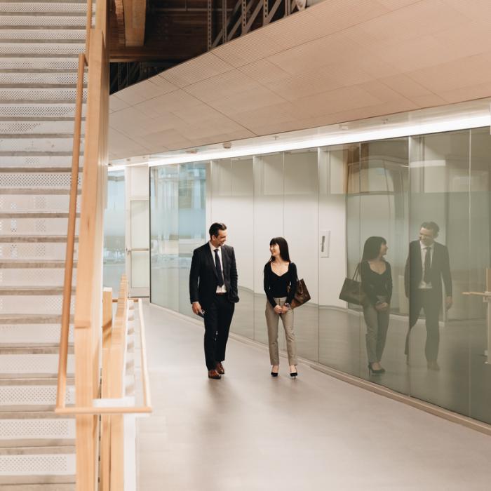 student walking with professor in business building