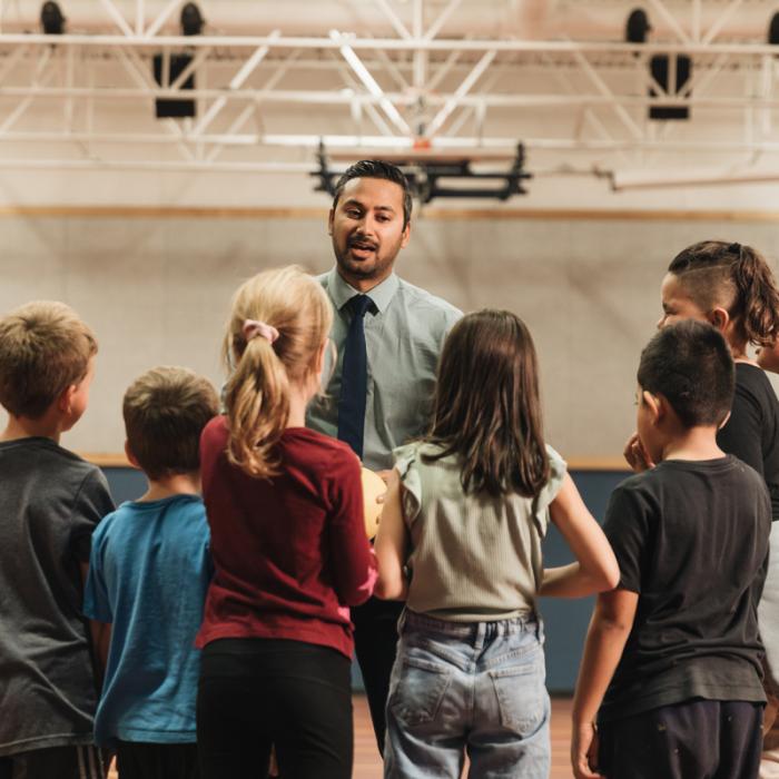 teacher talking with students in gym