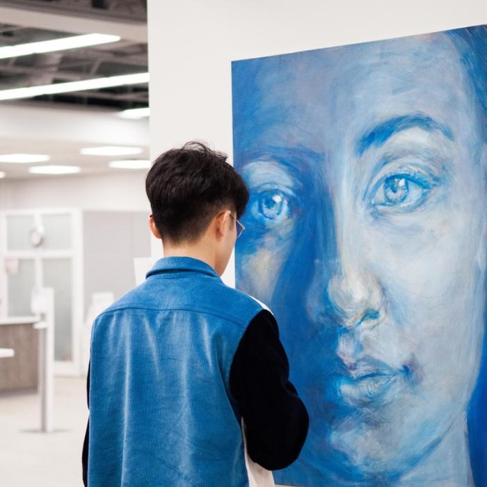 student looking at art in gallery exhibit