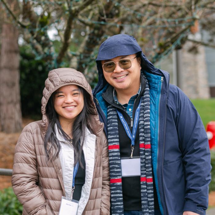 father and daughter smiling outside in rain jackets