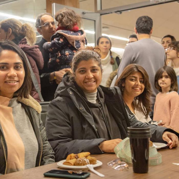 women sitting at a table smiling at the camera
