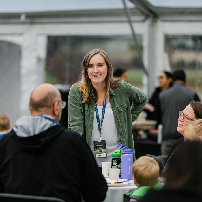 women standing at table talking to people