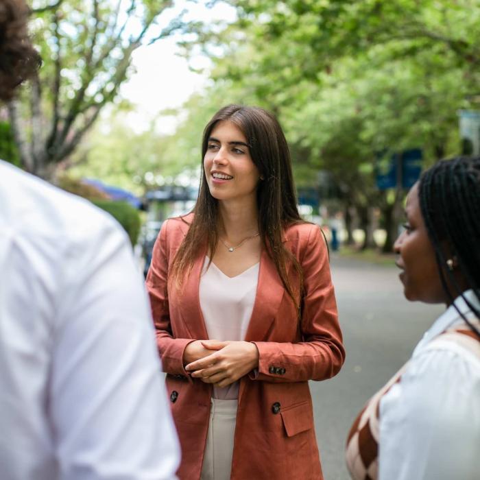 woman smiling and talking in a group outside