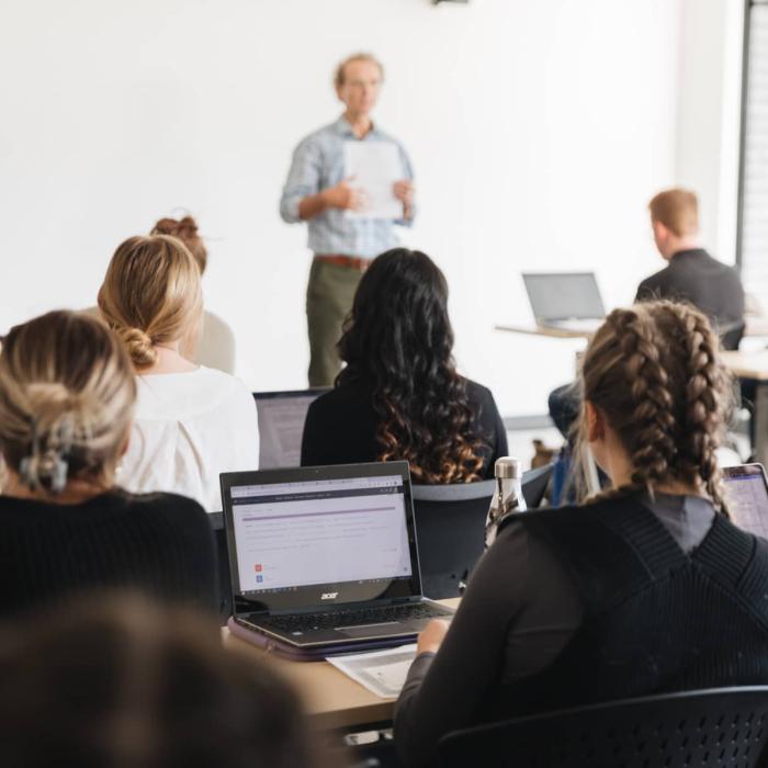 students sitting in a classroom listening to professor