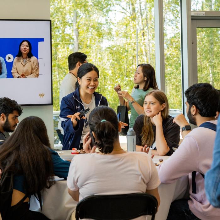 woman talking to a table of students in the Global Lounge